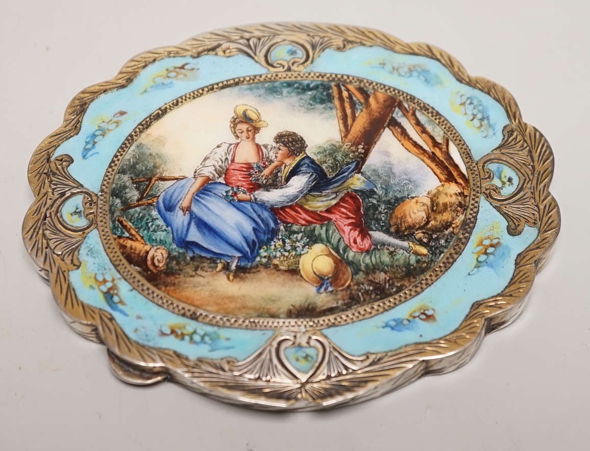 An early 20th century Austro-Hungarian? 800 standard white metal and polychrome enamelled cusped oval box and cover, the cover decorated with lady and gentleman at leisure, 97mm.